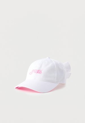 Valge Nike pesapalli nokamüts roosa logoga tikandiga ja selja taga seotud kangavibuga.