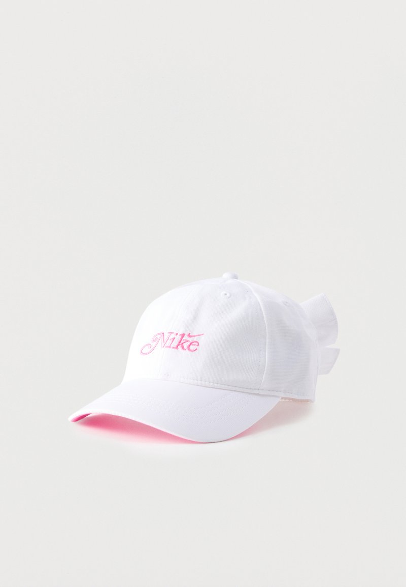 Άσπρο καπέλο μπέιζμπολ Nike με ροζ κέντημα λογότυπου και υφασμάτινο φιόγκο δεμένο στο πίσω μέρος.