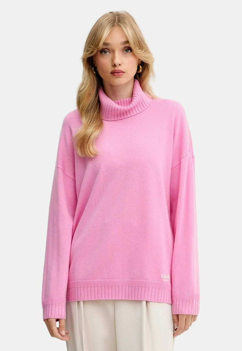 Maglione a collo alto rosa in tessuto morbido con colletto e orlo a coste. Vestibilità ampia con spalle scese e piccolo dettaglio del logo nella parte inferiore.