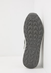 Sole in gomma grigia con motivo testurizzato, contrassegnata con "GEOX ITALIAN PATENT", che mostra un design ventilato. Bordo bianco lungo la suola esterna.