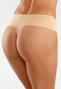 Beige naadloze hipster onderbroek, met een gladde textuur en een minimalistisch ontwerp, met een lage taille en subtiele stikdetails.