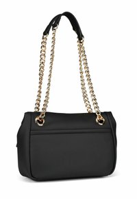 Borsa a mano in pelle nera con catene d'oro e hardware circolare. Presenta una forma strutturata e una texture liscia, con un dettaglio di cucitura anteriore.