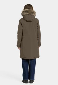 Oliven grøn parka med faux fur hætte, lange ærmer, sidelommer og lige skæring. Lavet af vandafvisende materiale.