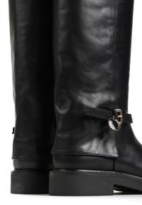 Czarne skórzane kozaki do kolan o gładkiej fakturze, z złotym akcentem klamry i paskiem w okolicy kostki. Płaska czarna podeszwa.