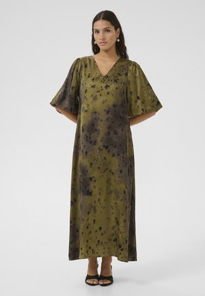 Robe longue vert olive avec un décolleté en V, des manches courtes bouffantes et des motifs de taches noires. Tissu lisse et fluide avec une coupe décontractée.