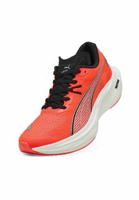 Roter Sportschuh mit einem strukturierten Mesh-Obermaterial, schwarzen Akzenten und reflektierenden silbernen Details an der Seite. Verfügt über eine gepolsterte weiße Sohle.