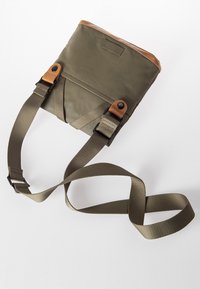 Borsa verde oliva con parte superiore in pelle marrone, forma rettangolare, spallacci regolabili e chiusure a scatto; texture liscia, design minimalista.