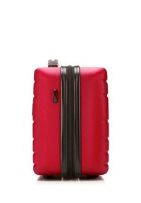 Maleta dura roja con una superficie texturizada, dos cremalleras negras y un asa retráctil. Presenta una forma cuadrada compacta.
