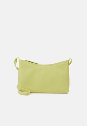 Kleine lichtgroene leren crossbodytas met ritssluiting en een dunne verstelbare riem tegen een witte achtergrond.