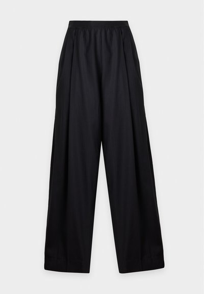 Pantalon noir à jambes larges avec une taille élastique et une coupe ample, présenté sur un fond gris clair uni.