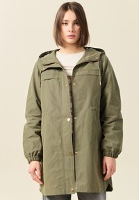 Parka vert olive avec capuche, poignets élastiques, poches avant, fermeture à pression et à zip, et coupe décontractée. Tissu léger avec une texture lisse.