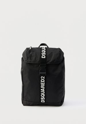 Sac à dos rectangulaire noir avec rabat avant, poche zippée et logo blanc "DSQUARED2" sur la sangle verticale et la poignée.