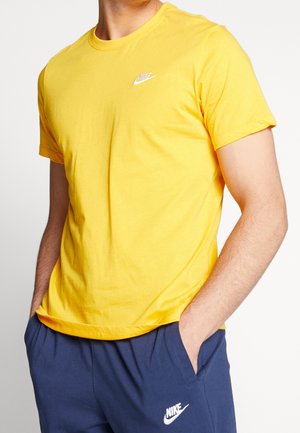 Żółta bawełniana koszulka z okrągłym dekoltem i krótkimi rękawami. Posiada małe białe logo Nike po lewej stronie klatki piersiowej.