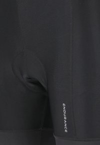 Svarta träningsshorts med vadderad insats, slät textur och ordet "ENDURANCE" tryckt på sidan i vitt.