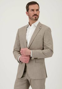 Lichtbeige pak met een gestructureerde stof, slim fit, reverskraag en twee knopen. Witte overhemden eronder. Geen zichtbare patronen.