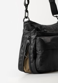 Borsa a spalla nera in tessuto con una texture liscia, dotata di una tasca con zip, fodera interna color tortora e una robusta tracolla nera con clip a moschettone.