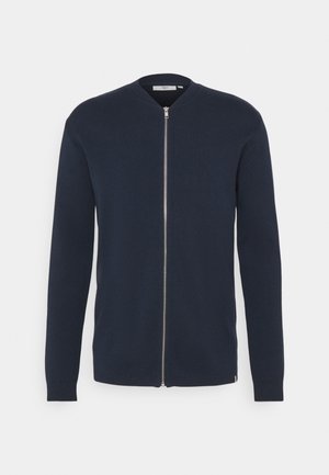 Cardigan en maille bleu marine à manches longues, col rond et zip avant intégral. Présente des poignets et un ourlet côtelés, une texture lisse et un design minimaliste.