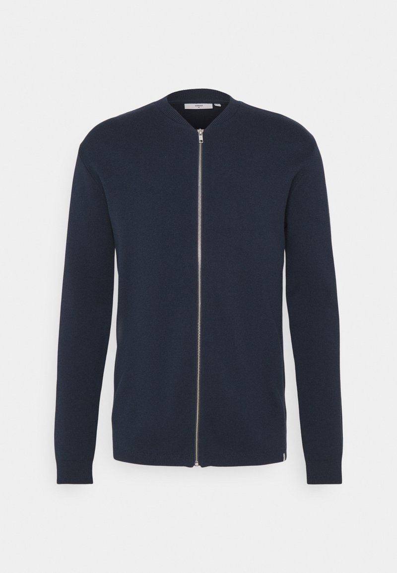 Cárdigan de punto azul marino con mangas largas, cuello redondo y cremallera frontal completa. Cuenta con puños y dobladillo acanalados, textura suave y diseño minimalista.