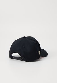 Boné preto com aba curva, fita ajustável na parte de trás e bordado discreto do logo na lateral, feito de um tecido texturizado.