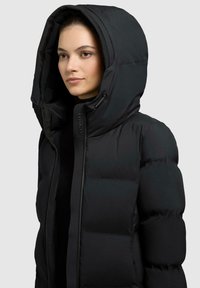 Zwarte pufferjack met een grote capuchon, voorzien van een ritssluiting, opvallende gekruiste textuur en een luxe, matte afwerking.