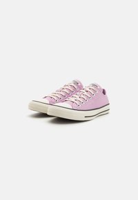 Sneakers di tela viola con suole in gomma bianca, striscia nera, punta rotonda e design con lacci a sei fori. Parte superiore testurizzata.