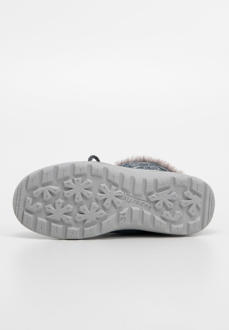 Semelle de chaussure grise avec un motif texturé comportant des formes de flocons de neige pour une meilleure adhérence. Matériau supérieur doux et plus sombre avec un bord en fourrure rose autour de la cheville.