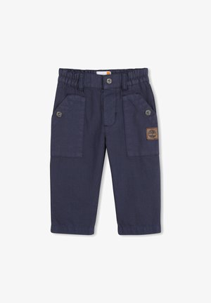 Pantalon en coton bleu marine avec une ceinture élastique, deux poches latérales, des accents de boutons et un petit patch logo marron.