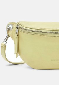 Gul läderpungväska med en rundad form, silverfärgad dragkedja och justerbar rem. Slät textur med subtilt varumärkestecken.
