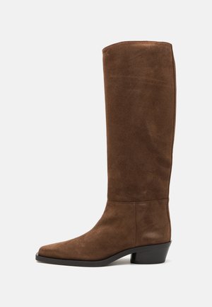 Hohe braune Wildlederstiefel mit quadratischer Zehenpartie und moderatem Absatz, die eine glatte Textur und ein elegantes, tailliertes Design aufweisen. Keine sichtbaren Beschläge oder Akzente.