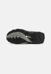 Trail shoe outsole featuring a black and gray rubber base, aggressive tread pattern, and embossed brand logo for traction and durability.