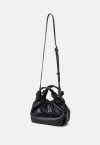 Sac à main en cuir noir avec un design froncé, deux poignées et une bandoulière amovible. Texture lisse avec un léger éclat.