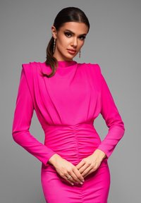 Tight passande rosa klänning med långa ärmar, rynkade detaljer vid midjan och strukturerade axlar. Slät tyg med en elegant design.