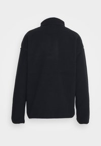 Giacca in pile nera con colletto alto, maniche lunghe e superficie testurizzata. Cuciture visibili lungo l'orlo e i polsini. Design semplice e minimalista.