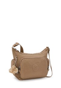 Brązowa torebka crossbody z przednią kieszenią na zamek błyskawiczny, bocznymi przegródkami, regulowanym paskiem oraz małym pluszowym brelokiem w kształcie małpki.