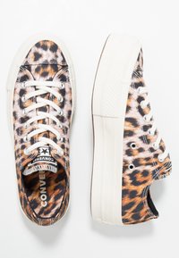 Niskie trampki platformowe Converse z białymi sznurówkami w brązowo-czarny wzór w panterkę.