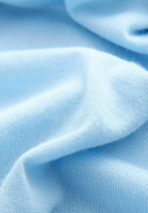 Material de culoare albastră deschisă, cu o textură netedă, având un model tricotat și o ușoară elasticitate, ce prezintă un cădere moale și fibră subtire.