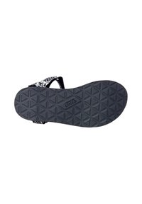 Suela de sandalia con patrón en blanco y negro y un agarre texturizado en forma de hexágono. Cuenta con correas ajustables para mayor comodidad y soporte.