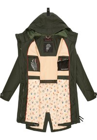 Veste à capuche vert foncé ouverte, dévoilant une doublure en polaire crème et une jupe intérieure matelassée à motif floral, avec plusieurs poches intérieures et étiquettes de marque.