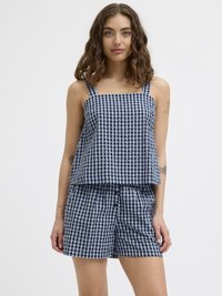 Top sans manches à carreaux bleu marine et clair avec un col carré, associé à un short assorti avec une fermeture à bouton.