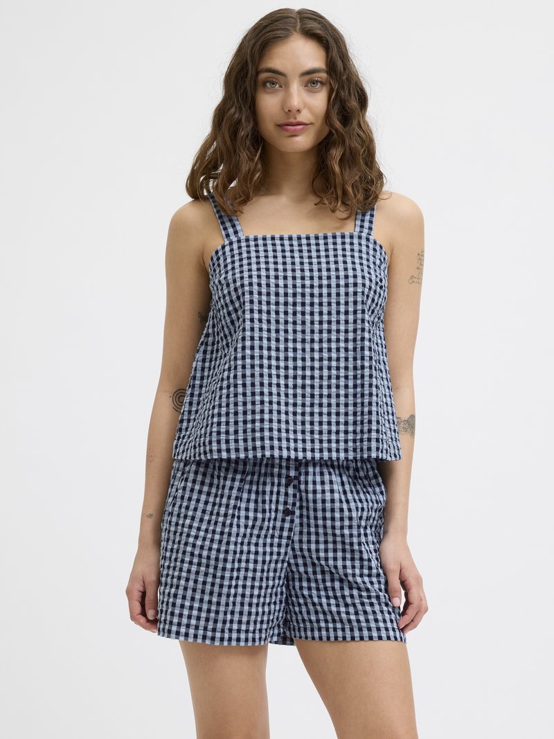 Top sans manches à carreaux bleu marine et clair avec un col carré, associé à un short assorti avec une fermeture à bouton.