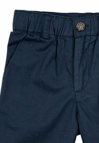 Mörkblå shorts med elastisk midja, med en knappstängning fram och sidofickor. Tillverkade av mjukt, texturerat tyg.