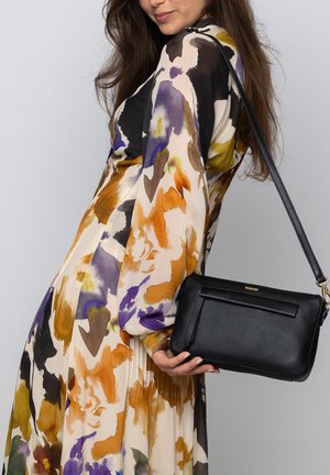 Black leather handbag with a textured finish and a detachable strap, featuring a front pocket and gold-tone hardware accents.