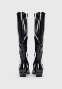 Botas negras hasta la rodilla, hechas de cuero brillante con un diseño aerodinámico, que cuentan con un cierre de cremallera en la parte trasera y un tacón de forma cuadrada.