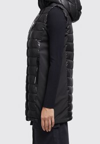 Czarna puchowa kamizelka z błyszczącym, pikowanym wykończeniem, bez rękawów i z kapturem. Posiada boczny zamek oraz kontrastowy panel z tkaniny.