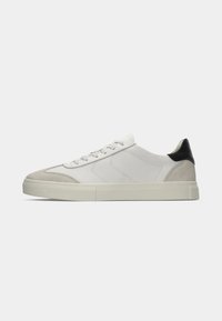 Sneaker bianca con dettagli in camoscio, finitura liscia, suola leggera e tallone nero, dotata di chiusura con lacci e cuciture a contrasto.