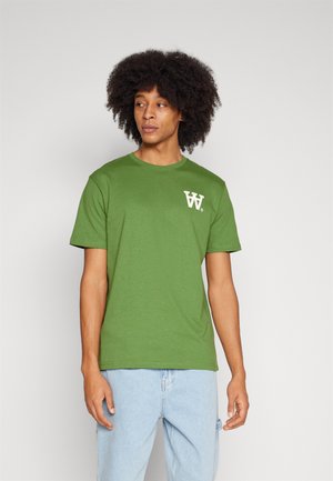 Green cotton t-shirt with short sleeves and a crew neck, featuring a white logo on the left chest area. Soft texture and casual fit.