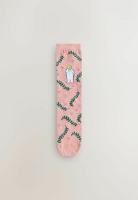 Pink sock featuring green leafy patterns, small pink hearts, and a white cartoon figure in a winter outfit. Soft fabric with textured details.