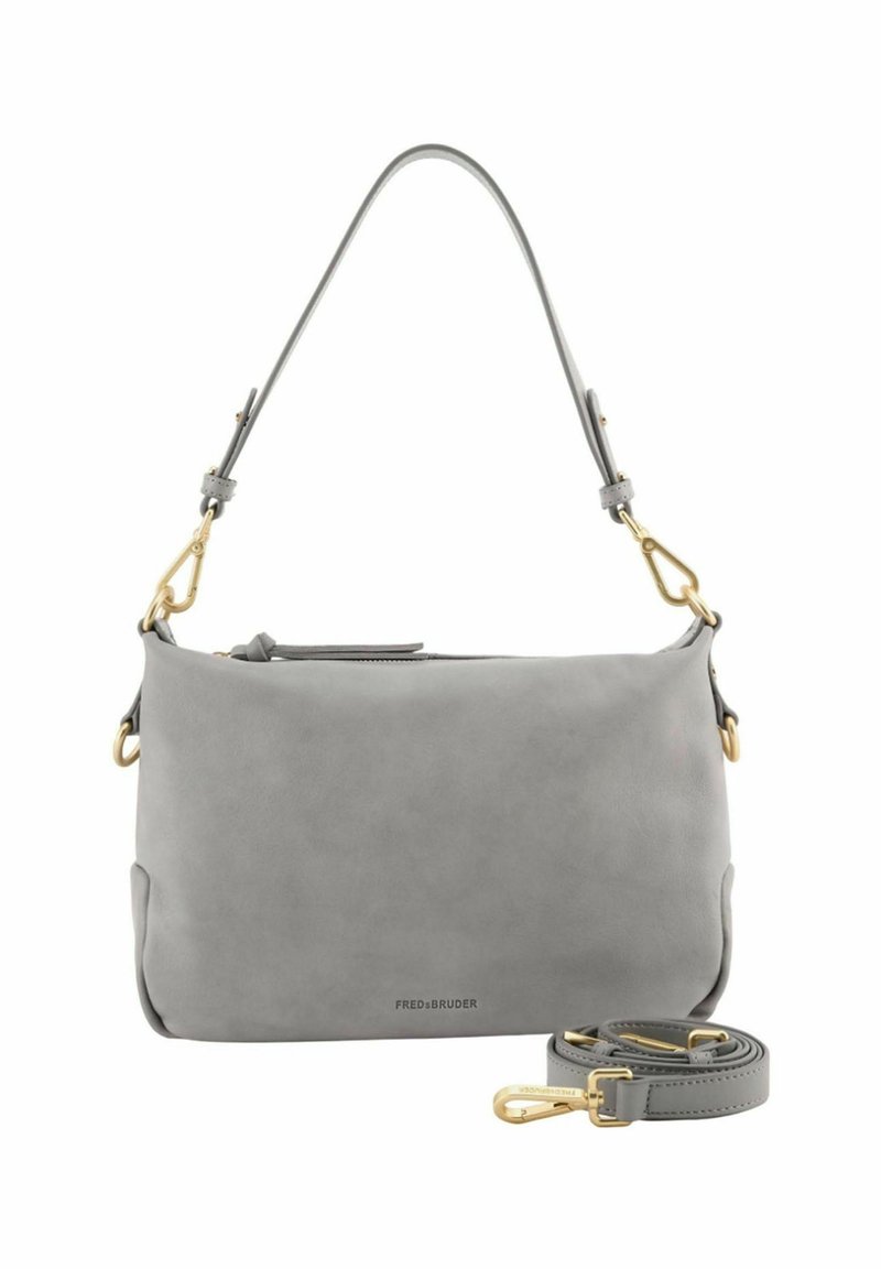 Sac à main en cuir gris doux avec des fermoirs dorés, portant une courte bandoulière fixée, et une bandoulière plus longue amovible enroulée à côté.