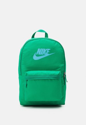 Zaino in nylon verde con parte superiore arrotondata, dotato di una grande tasca frontale con zip e di un prominente logo Nike blu. Spallacci regolabili.