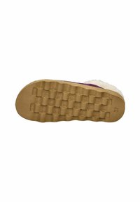 Suela de una zapatilla con una base de goma lisa y marrón claro, con un patrón texturizado y una impresión de tamaño, rodeada de material suave y blanco.
